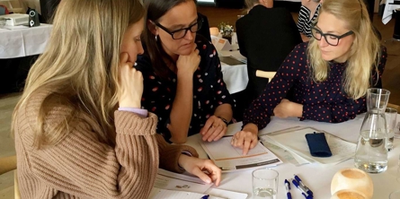 Medarbejdere er på kursus og sidder sammen og løser en opgave