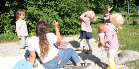 Voksen og børn kigger efter flyvemaskine på himlen