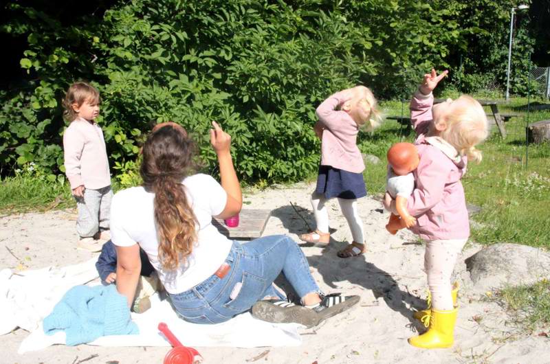 Voksen og børn kigger efter flyvemaskine på himlen