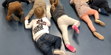 En flok børn kryber hen ad gulv i motorikrum