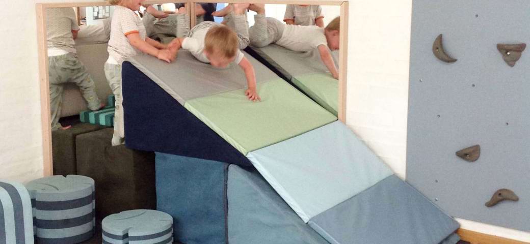 Børn der tumler på madrasser og Bobles-figurer