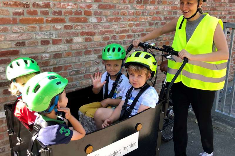 Voksen og fire børn på tur med ladcykel