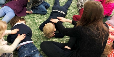Voksen og børn giver hinanden massage 
