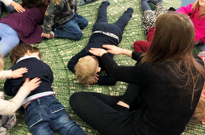 Voksen og børn giver hinanden massage